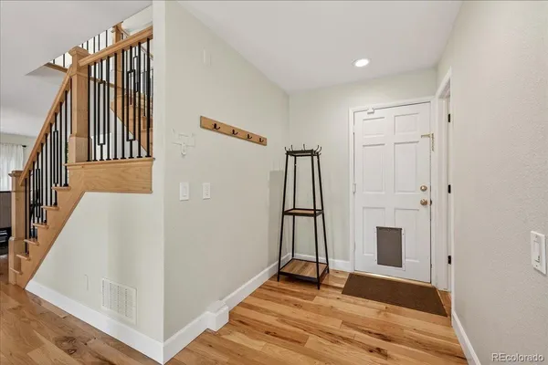 a view of a hallway with wooden floor and staircase