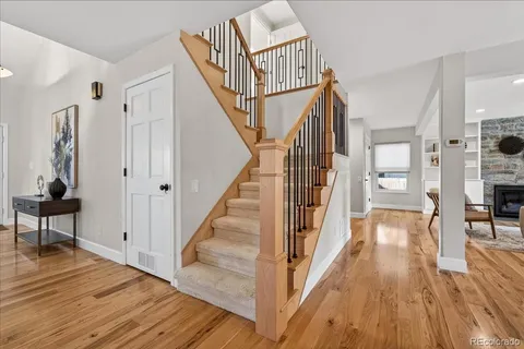 a view of a hallway with wooden floor and staircase
