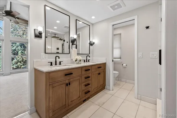 a spacious bathroom with a double vanity sink a mirror and a shower
