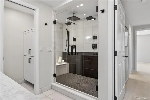 a bathroom with a glass shower door a sink and a mirror