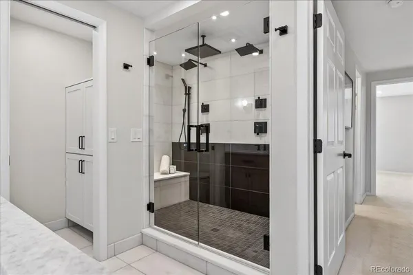 a bathroom with a glass shower door a sink and a mirror