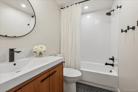 a bathroom with a sink a toilet and shower