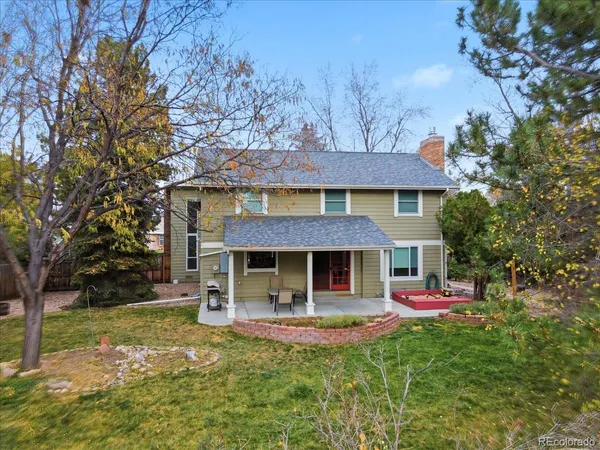a front view of a house with a yard and trees