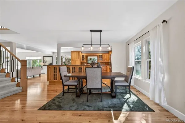 a dining room with wooden floor a glass table and chairs