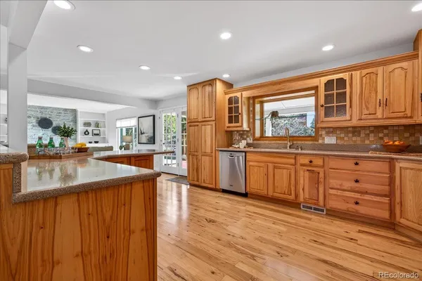 a kitchen with stainless steel appliances granite countertop a refrigerator a stove and a wooden cabinets