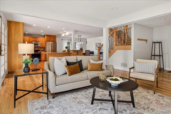 a living room with furniture and a wooden floor
