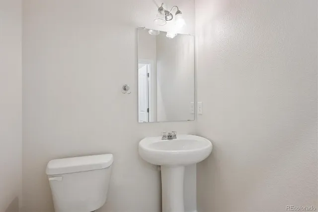 a bathroom with a sink toilet and a mirror