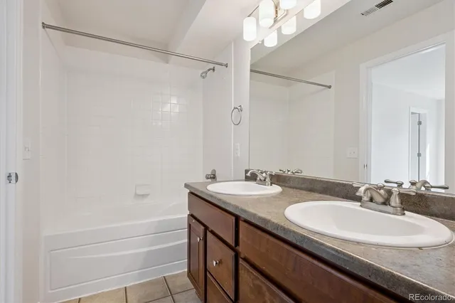 a bathroom with a sink double vanity mirror and a bathtub