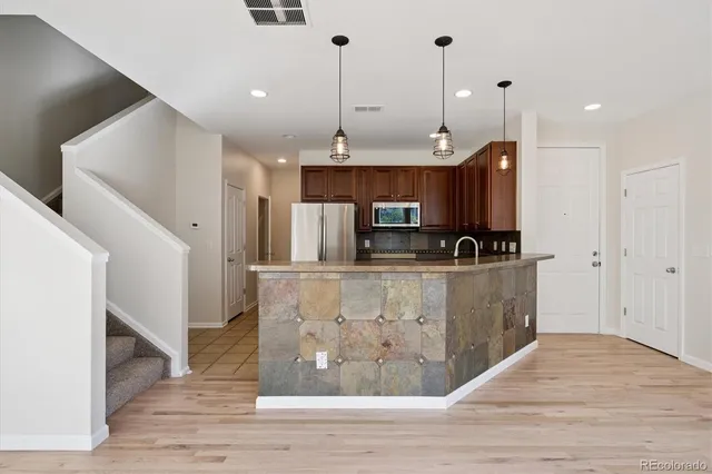 a kitchen with kitchen island a sink stainless steel appliances and cabinets