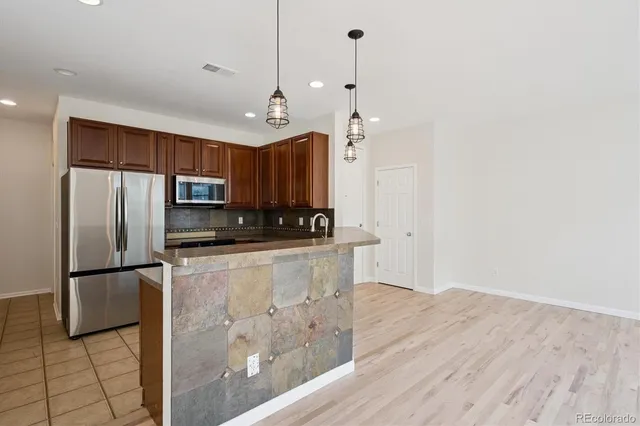 a kitchen with stainless steel appliances a refrigerator sink and microwave