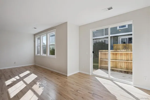 a view of empty room with wooden floor and windows