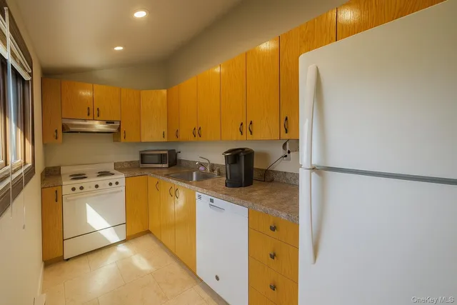 a kitchen with stainless steel appliances granite countertop a refrigerator a stove and a sink