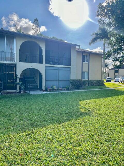 311 Pine Ridge Circle, Unit B1 Greenacres, FL 33463 - Photo 5 of 7 a view of a house with a backyard and a yard