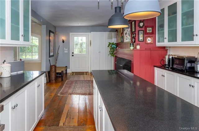 a view of a kitchen with granite countertop a sink a counter top space and cabinets