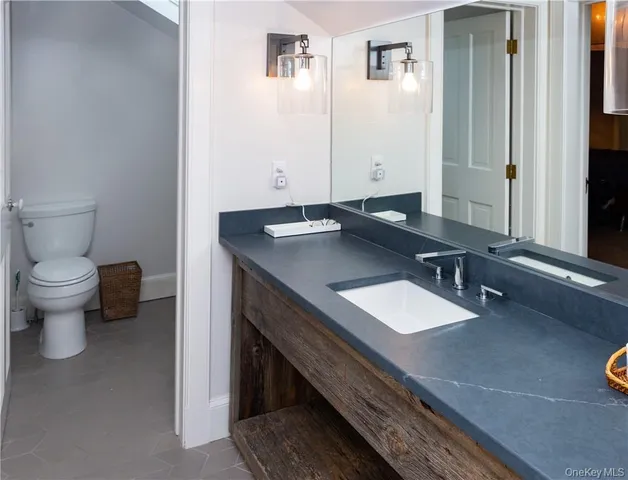 a bathroom with a sink a toilet and a mirror