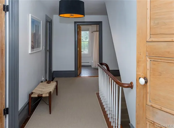 a view of a hallway with wooden floor and a dining room