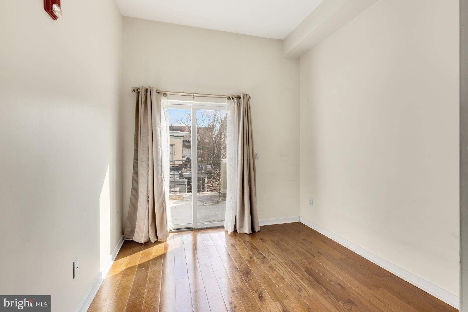 2031 South Juniper Street, Unit 204 Philadelphia, PA 19148 - Photo 13 of 31 an empty room with wooden floor and windows