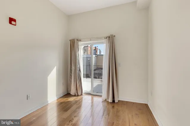 an empty room with wooden floor and a window