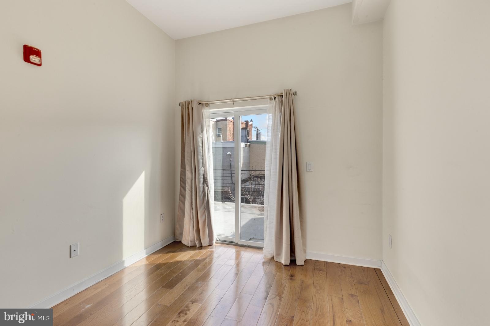 2031 South Juniper Street, Unit 204 Philadelphia, PA 19148 - Photo 15 of 31 an empty room with wooden floor and a window