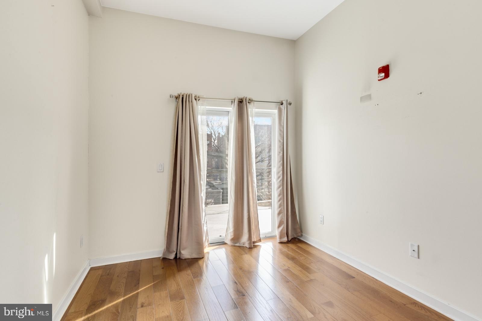 2031 South Juniper Street, Unit 204 Philadelphia, PA 19148 - Photo 20 of 31 an empty room with wooden floor and windows