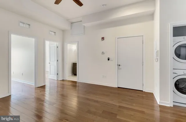 a view of a hallway with wooden floor and a sink