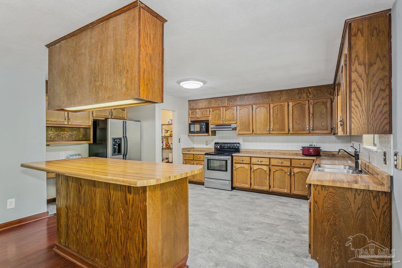 111 Cotton Creek Road McDavid, FL 32568 - Photo 13 of 37 a kitchen with a sink refrigerator and cabinets