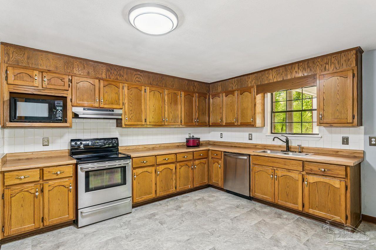 111 Cotton Creek Road McDavid, FL 32568 - Photo 14 of 37 a kitchen with a sink stove and microwave