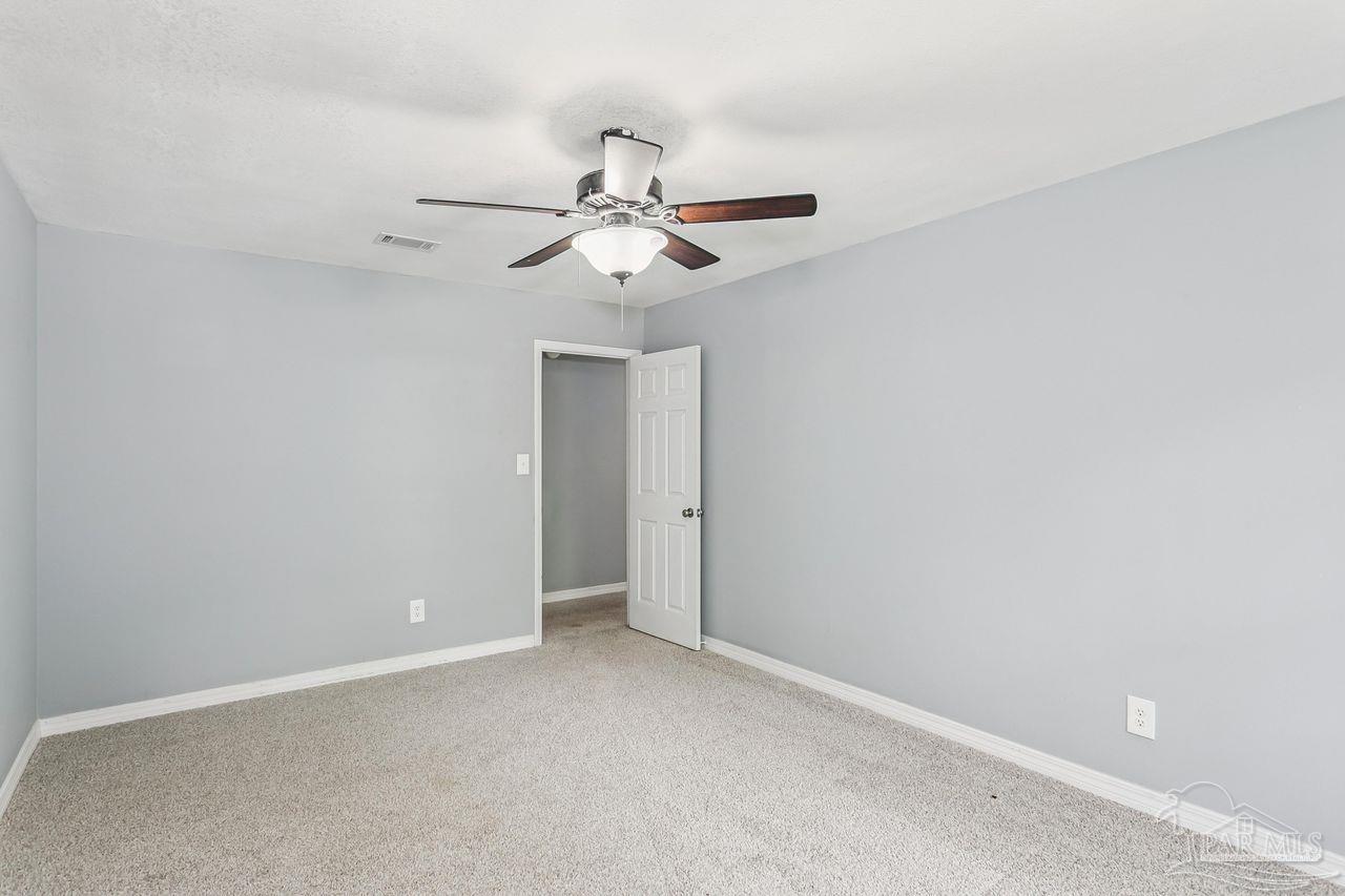 111 Cotton Creek Road McDavid, FL 32568 - Photo 18 of 37 an empty room with a window and a fan