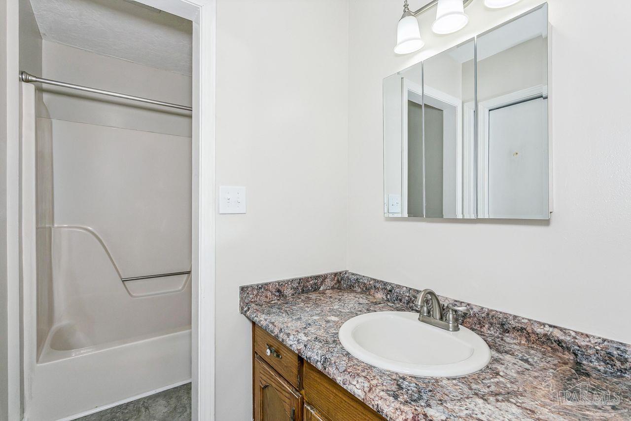 111 Cotton Creek Road McDavid, FL 32568 - Photo 21 of 37 a bathroom with a granite countertop sink and a mirror