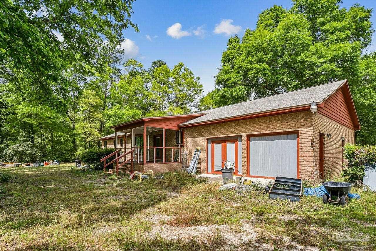 111 Cotton Creek Road McDavid, FL 32568 - Photo 30 of 37 a backyard of a house with potted plants and large tree