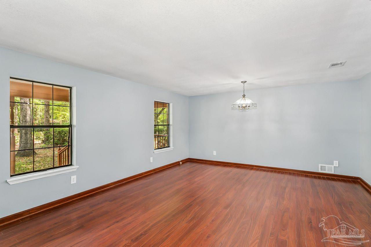 111 Cotton Creek Road McDavid, FL 32568 - Photo 7 of 37 wooden floor in an empty room with a window