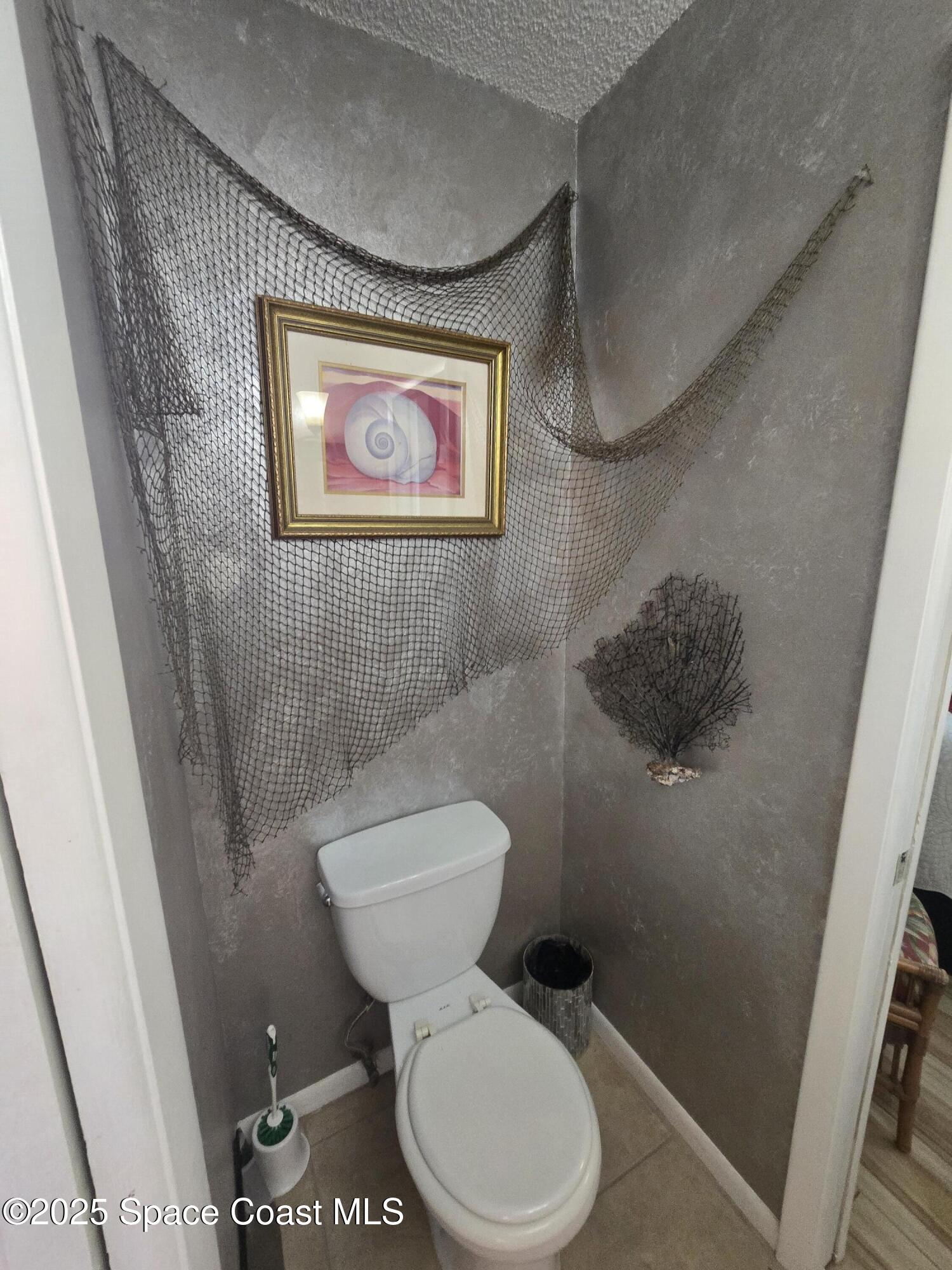 620 Ridge Club Drive, Unit 88 Melbourne, FL 32934 - Photo 13 of 18 a white toilet sitting next to a small bathroom sink and vanity
