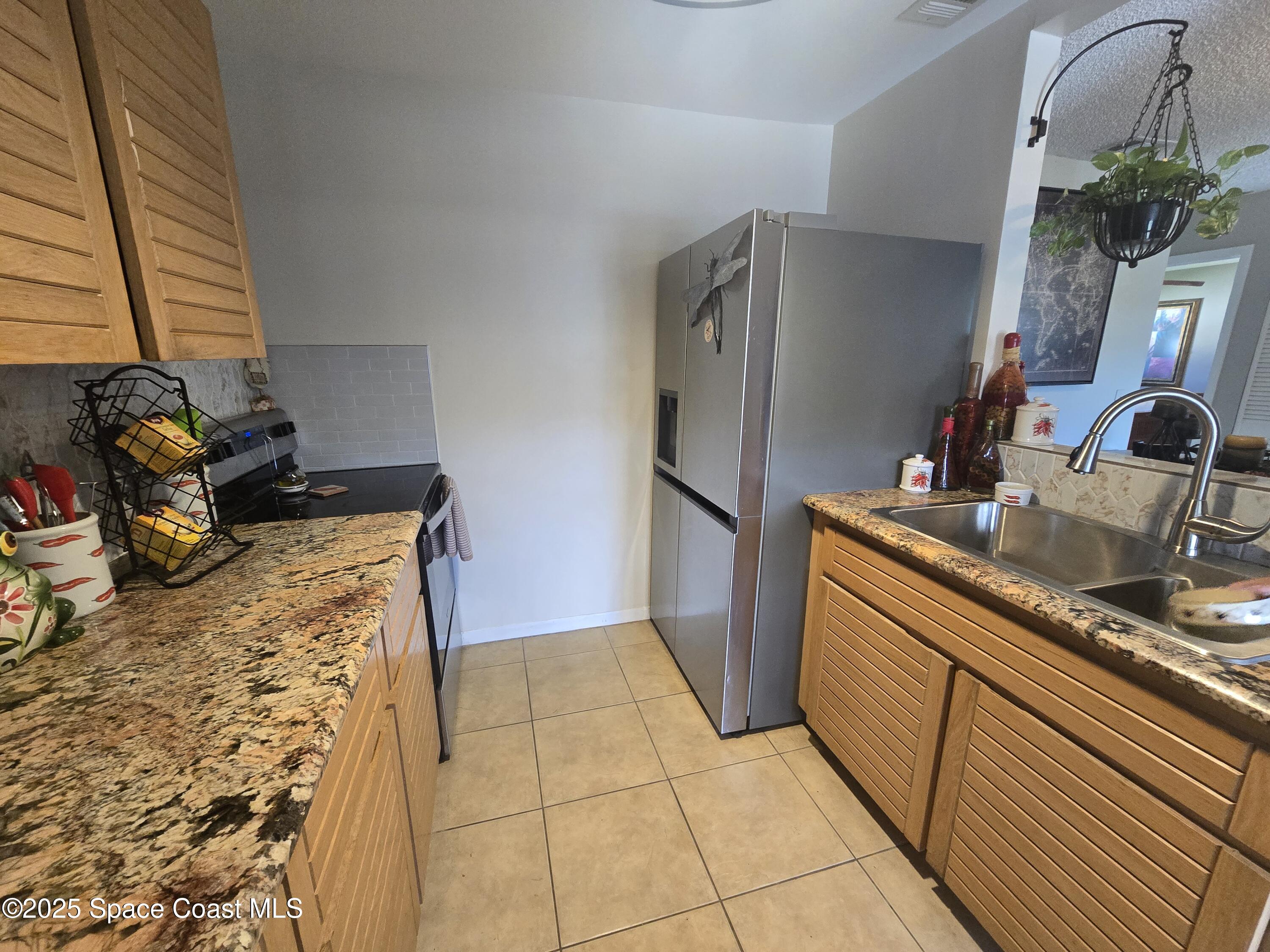 620 Ridge Club Drive, Unit 88 Melbourne, FL 32934 - Photo 3 of 18 a kitchen with stainless steel appliances granite countertop a sink stove and refrigerator