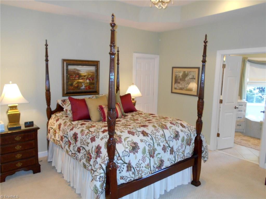 8643 Adkins Road Colfax, NC 27235 - Photo 14 of 30 Master bedroom has tray ceilings, sitting area, walk in closet and large master ensuite spa like bath.