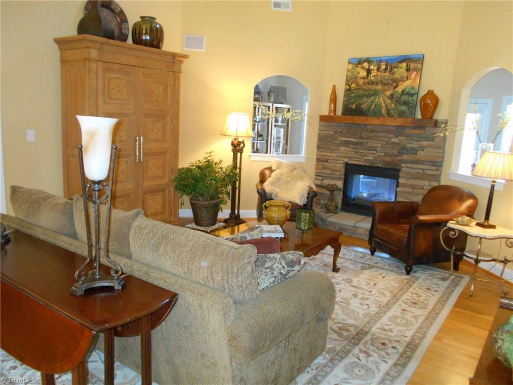 8643 Adkins Road Colfax, NC 27235 - Photo 6 of 30 Living room with extra tall ceilings, fan and gas log pass through fire place