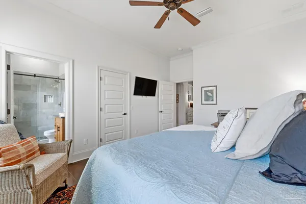 an empty room with chandelier fan and windows