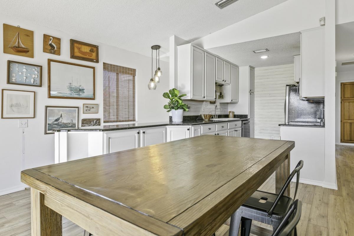5484 5th Street St. Augustine, FL 32080 - Photo 18 of 37 a kitchen with stainless steel appliances granite countertop a sink a microwave and wooden cabinets