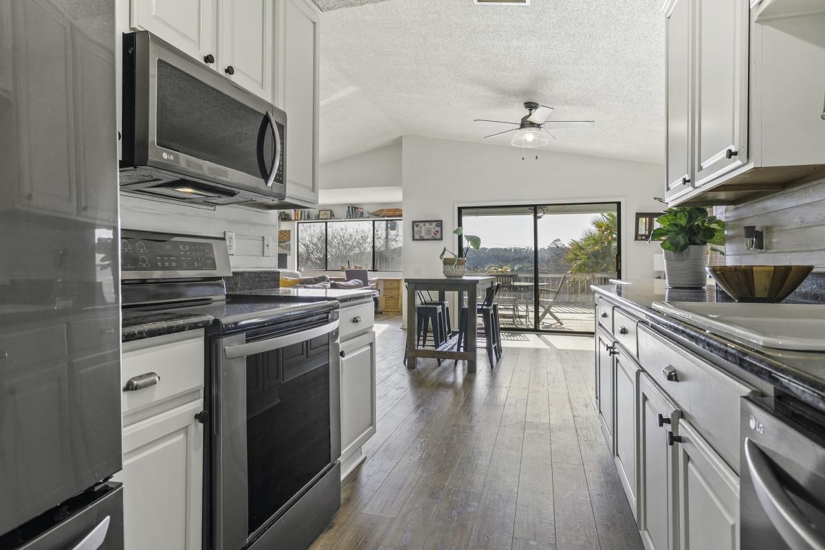 5484 5th Street St. Augustine, FL 32080 - Photo 19 of 37 a kitchen with stainless steel appliances a stove top oven a sink a dining table and chairs