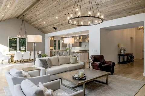 a living room with furniture a chandelier and a large mirror