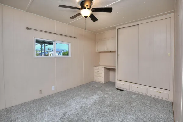 an empty room with chandelier fan