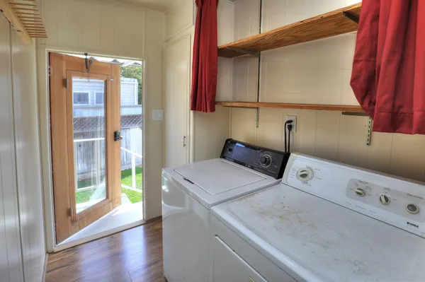 a view of a patio with couches chairs potted plants and wooden fence