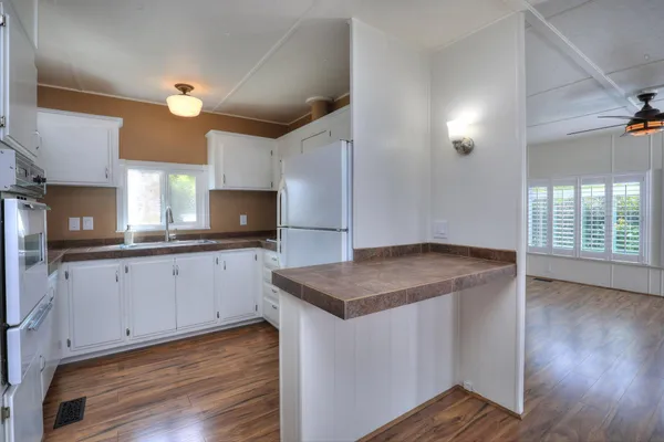 a kitchen with granite countertop a sink a stove and cabinets