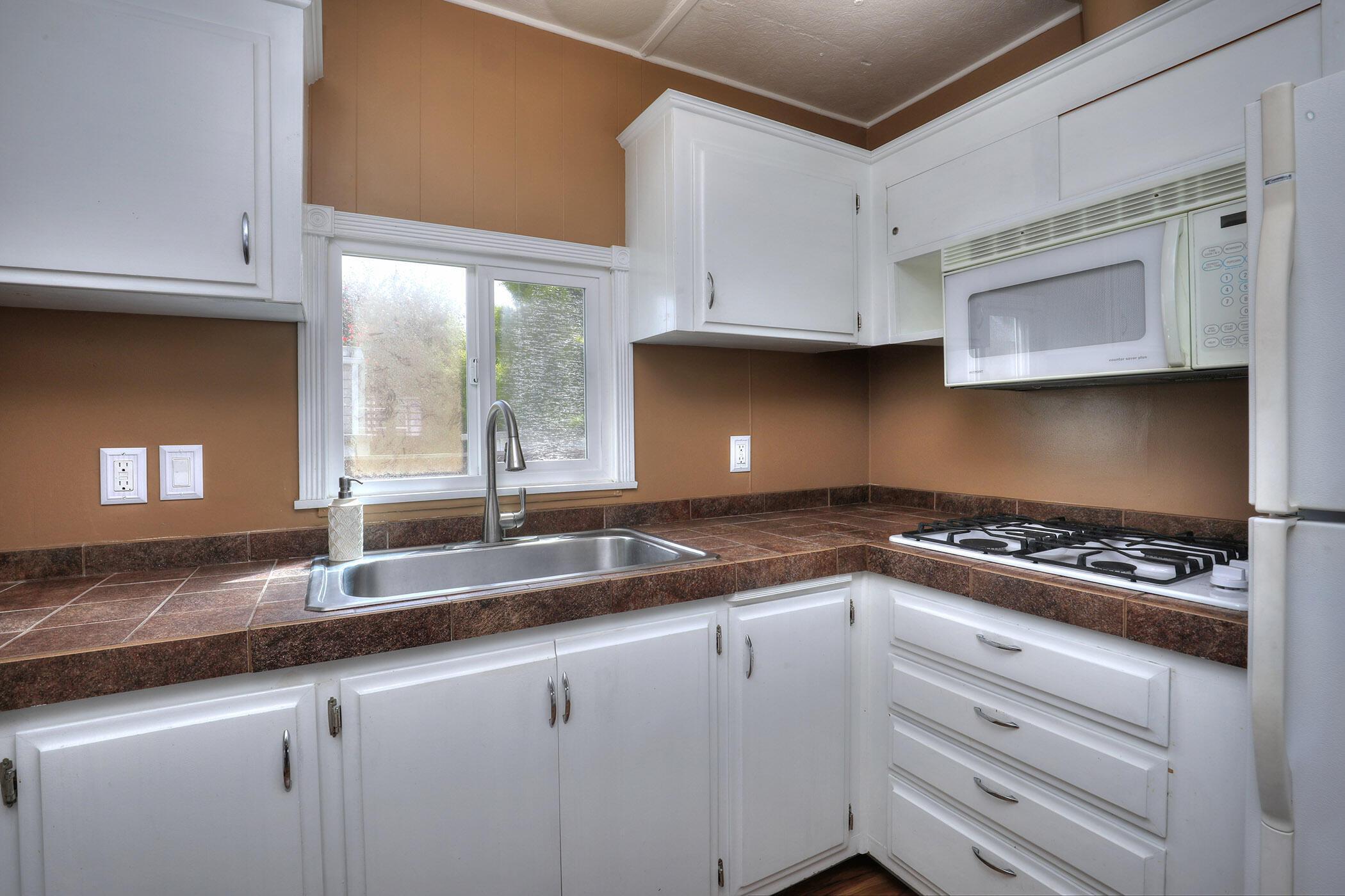 30 Winchester Canyon Road, Unit SPC 50 Goleta, CA 93117 - Photo 9 of 30 a kitchen with granite countertop a sink a stove and cabinets