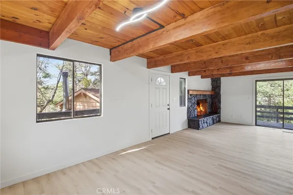 a view of empty room with wooden floor and fireplace