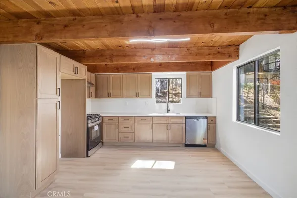 a large kitchen with window and stainless steel appliances