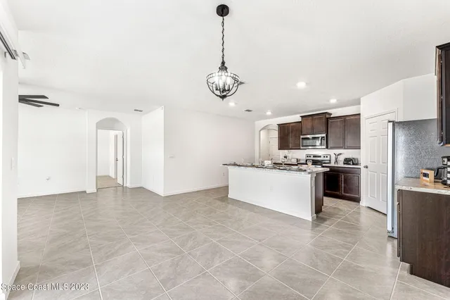 a large white kitchen with a stove a sink dishwasher and a refrigerator with wooden floor