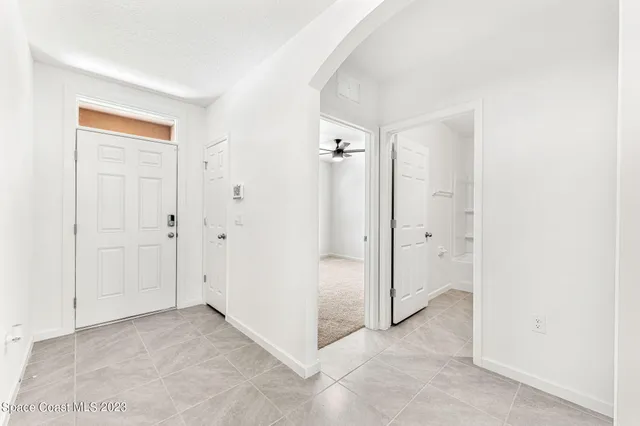 an empty room with a window and a fan