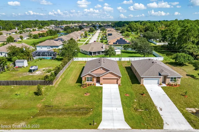 an aerial view of residential houses with outdoor space and swimming pool
