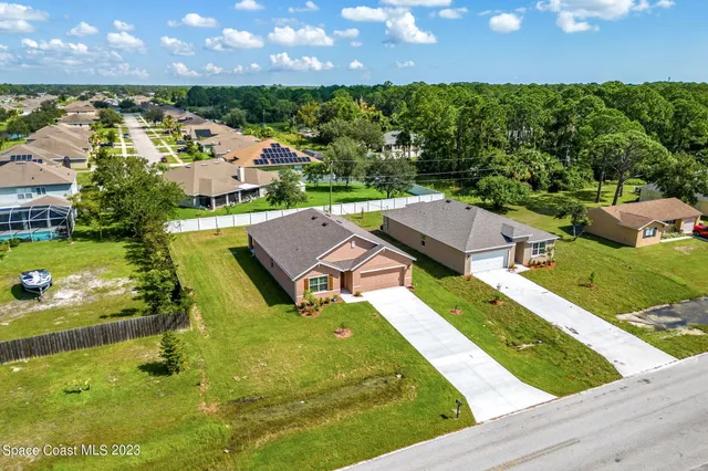 an aerial view of a house with swimming pool garden and outdoor seating