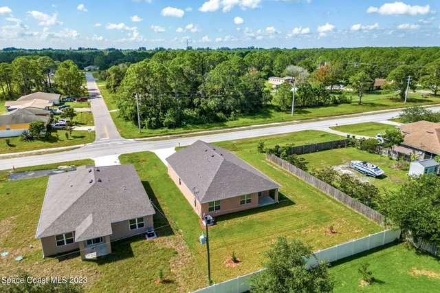 an aerial view of residential houses with outdoor space and swimming pool